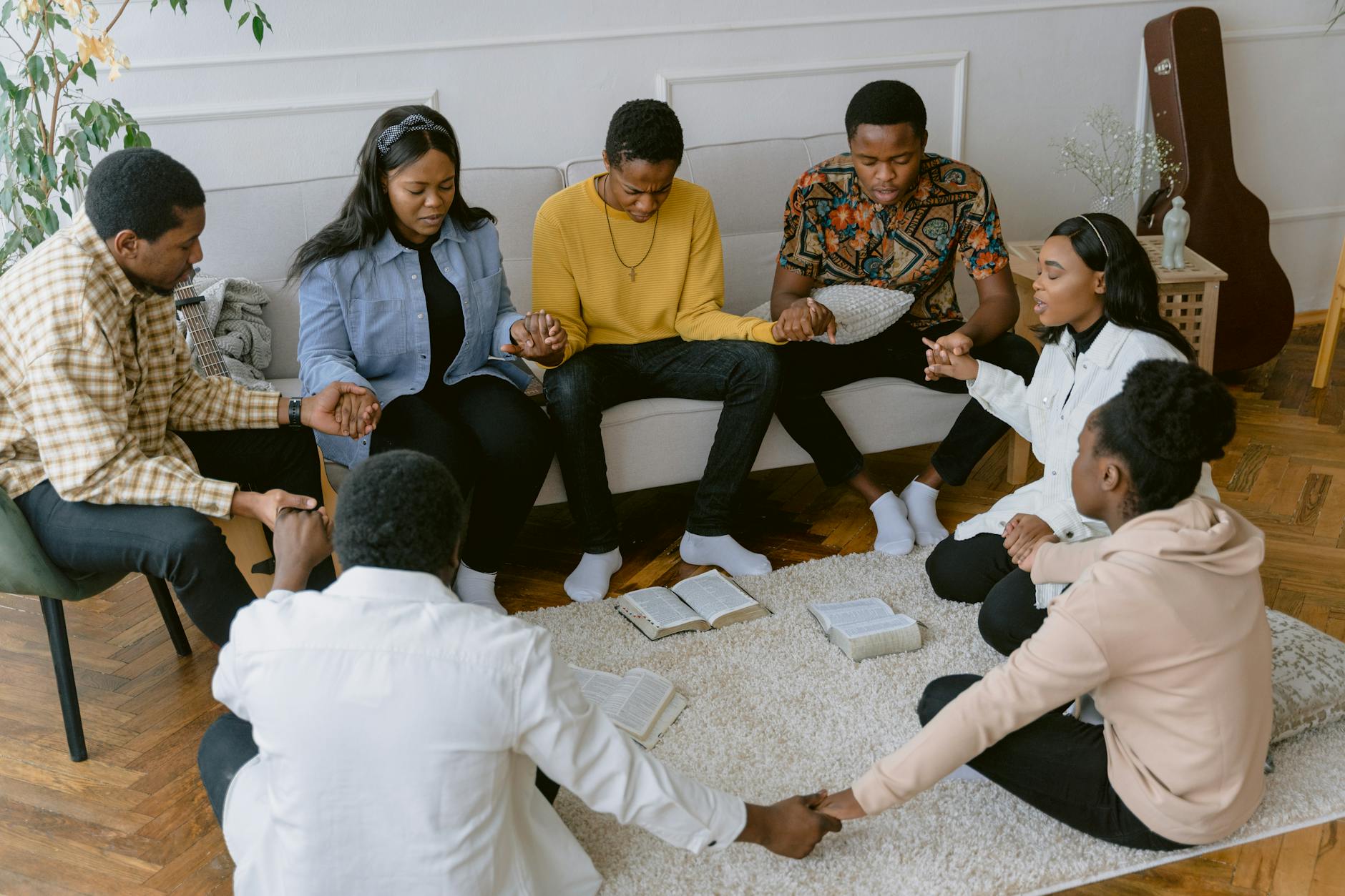 group of people praying in the living room