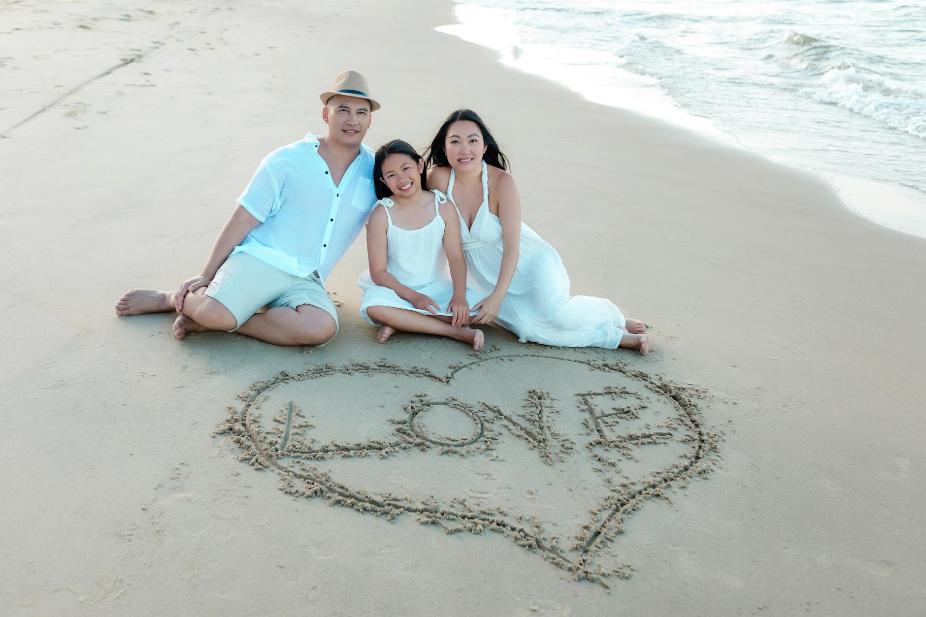 family on hoi an beach with sand heart
